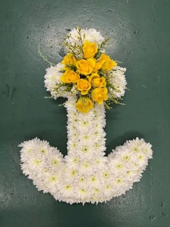 An anchor of white chrysanthemums, topped with yellow roses