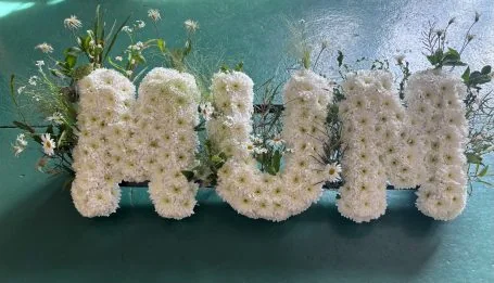 MUM spelt out in white chrysanthemums, threaded through with daisies